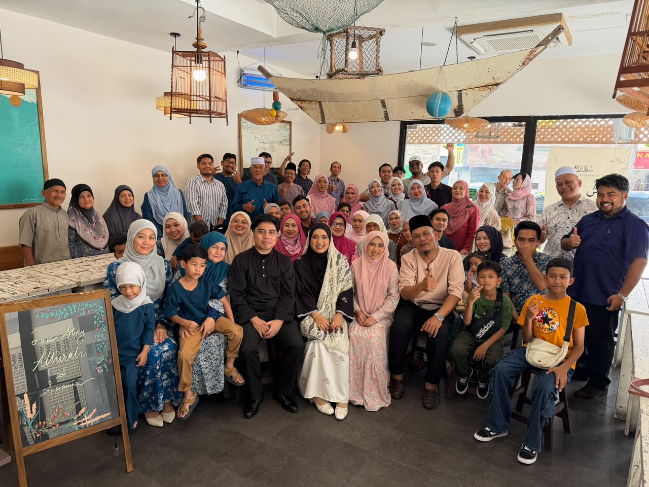 Athirah and Syamir surrounded by their family
